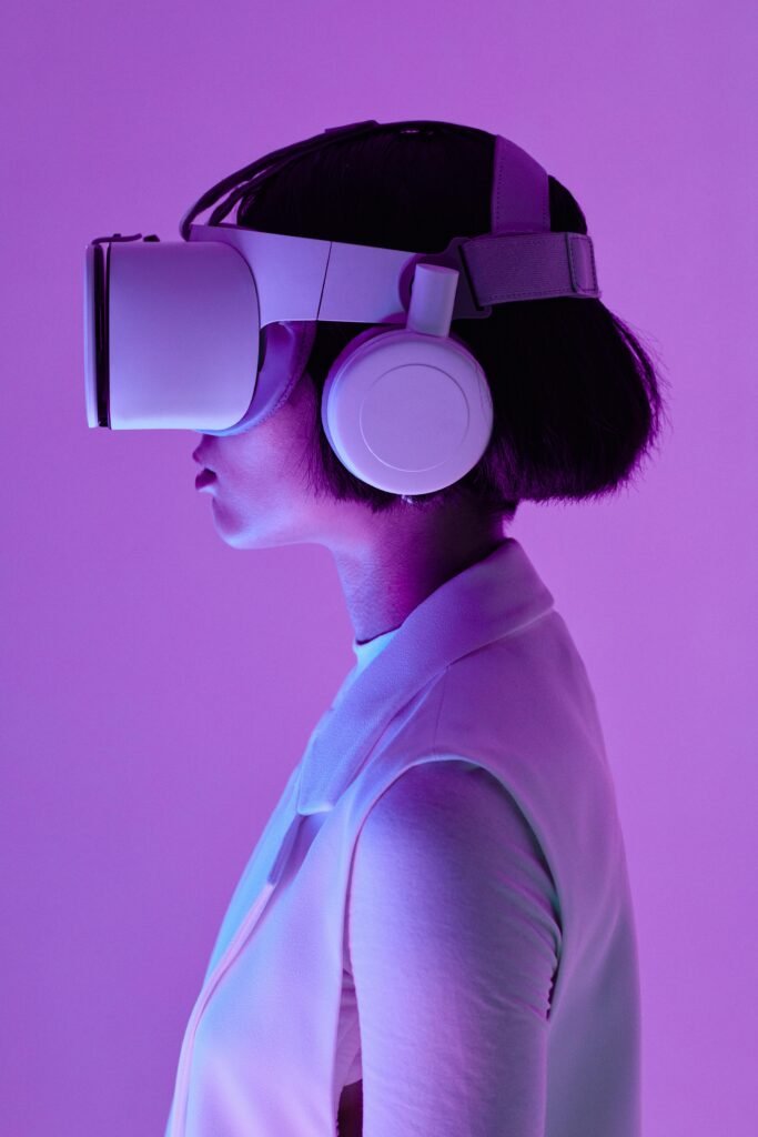 Home Side profile of a woman wearing VR goggles in a studio with purple lighting, embodying future tech.